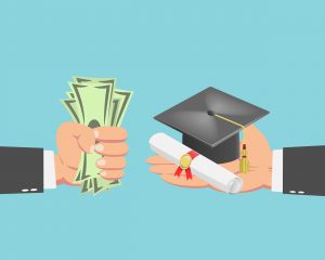 Hand of businessman with money buying a graduation cap and diploma scroll isolated on blue background